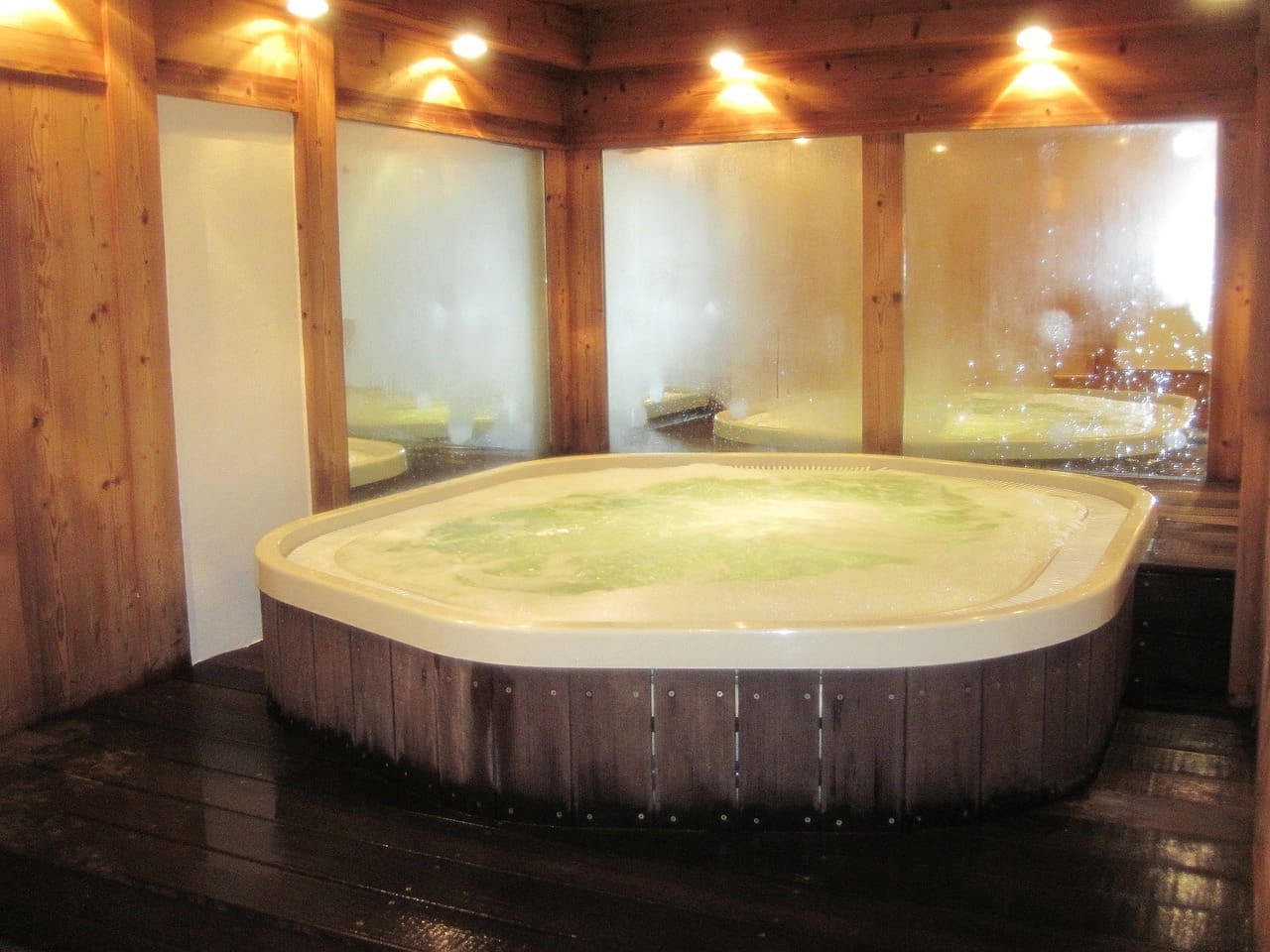A bathroom scene with a filled bathtub. On the water's surface, there's a thin film, and the water appears slightly murky, with a few bubbles rising.