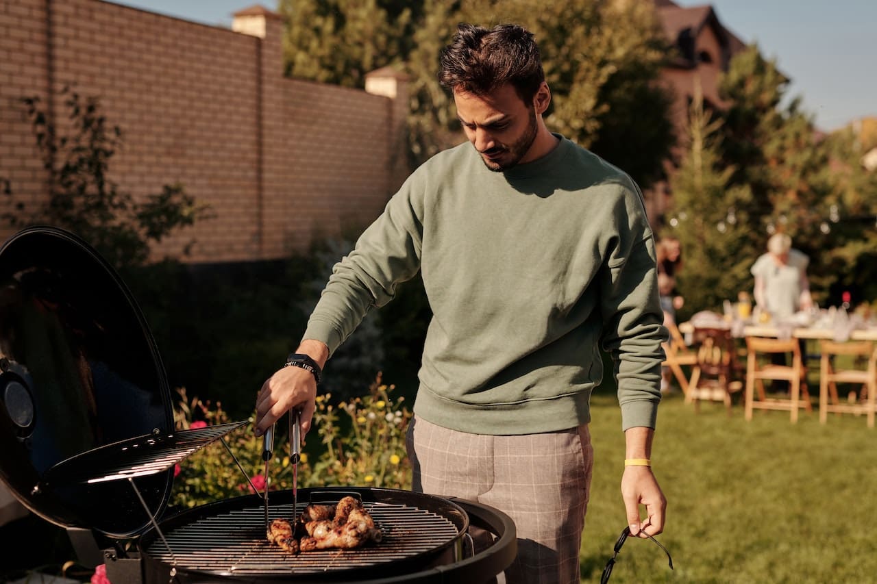 A cozy evening snapshot of friends gathered in their garden, enjoying a barbecue and outdoor games on a sunny day, with cool beverages made from pure water, illustrating the simple pleasures of outdoor living in Baytown.