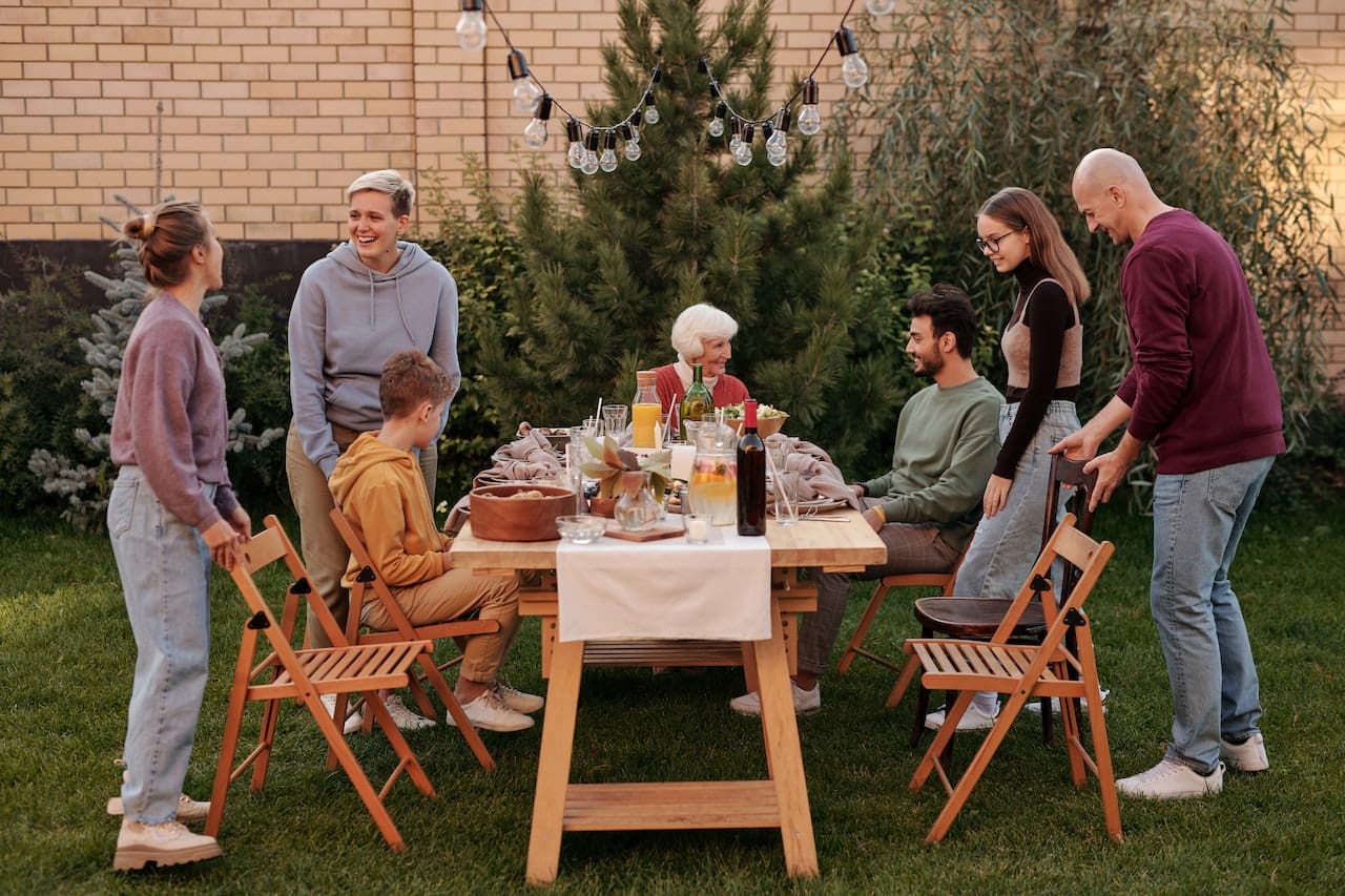 A heartwarming scene of a family enjoying a picnic in their backyard, under the shade of towering trees, sipping on refreshing beverages made with pure water, showcasing the joy of outdoor leisure in Conroe.
