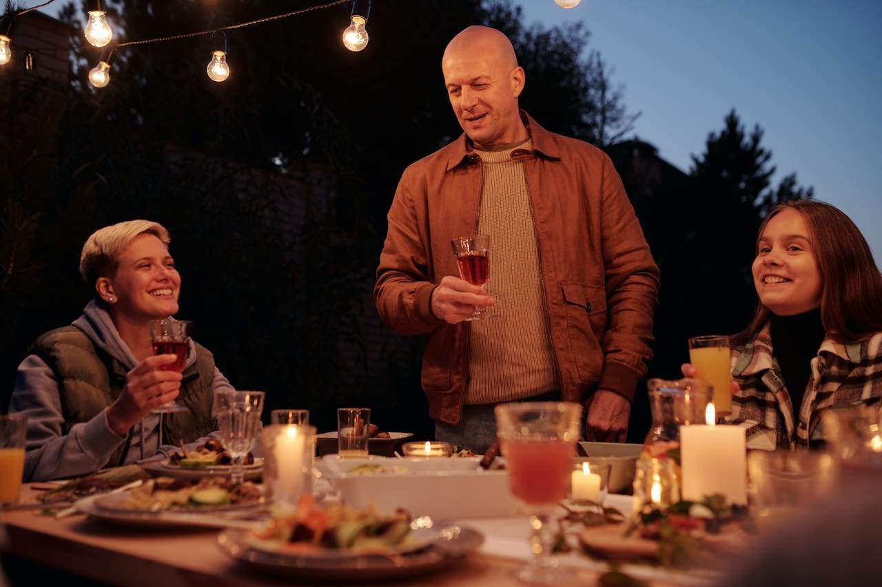 A cozy evening scene of a family enjoying a backyard barbecue with friends, sipping on refreshing beverages made with clean water, showcasing the warmth of home and outdoor living in Pearland.