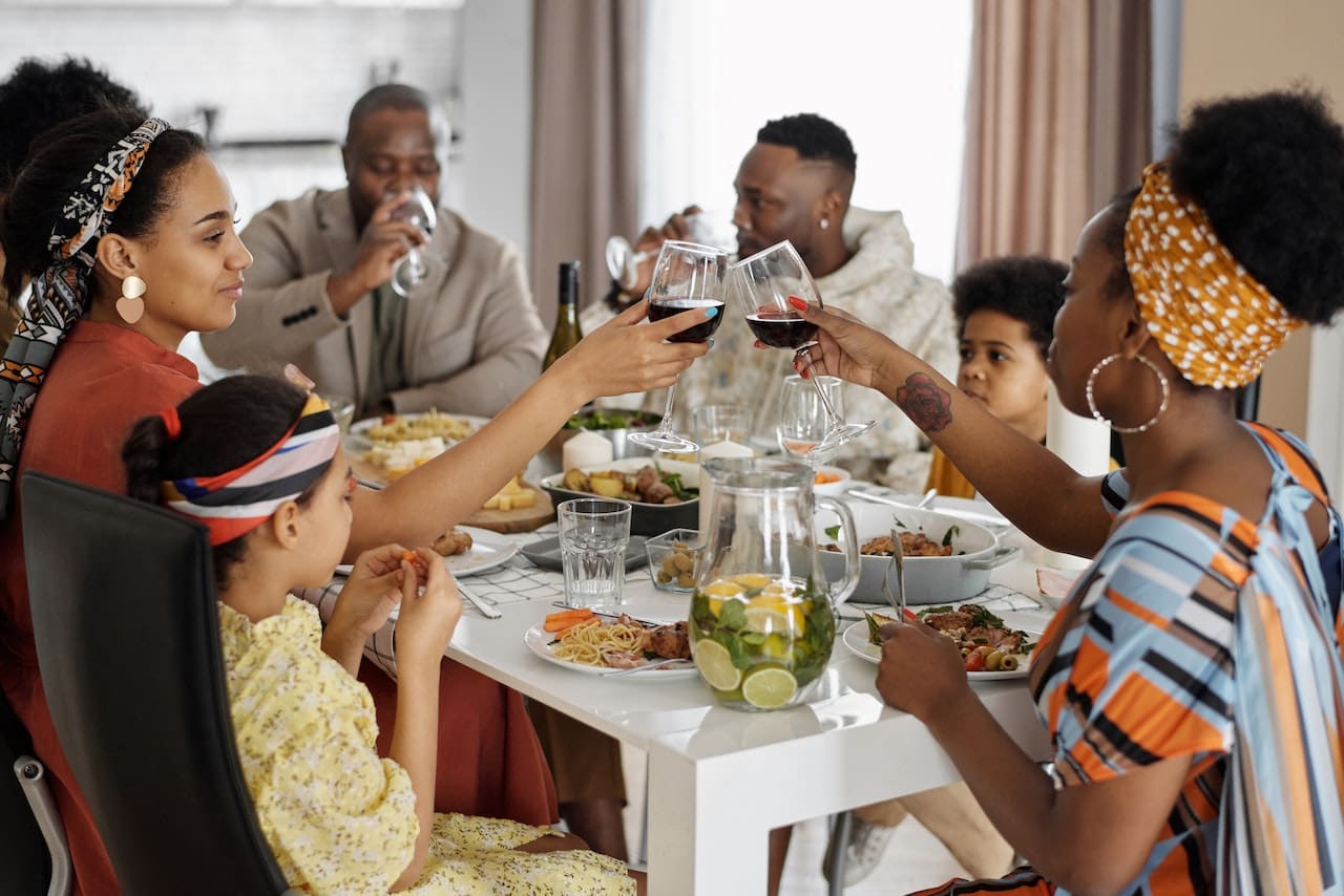 A photo-realistic image of a family enjoying a seafood barbecue on a waterfront deck, with glasses of chilled lemonade, celebrating the city's coastal cuisine.