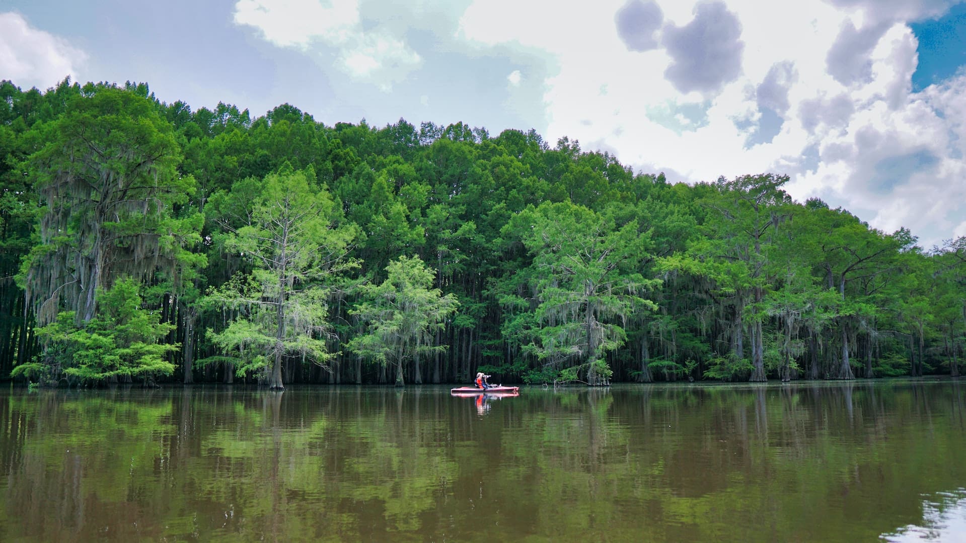 A captivating image showcasing the serene beauty of Lake Houston, with clear waters, boaters, and a picturesque sunset in the background, highlighting Atascocita's close connection to this tranquil natural landmark.