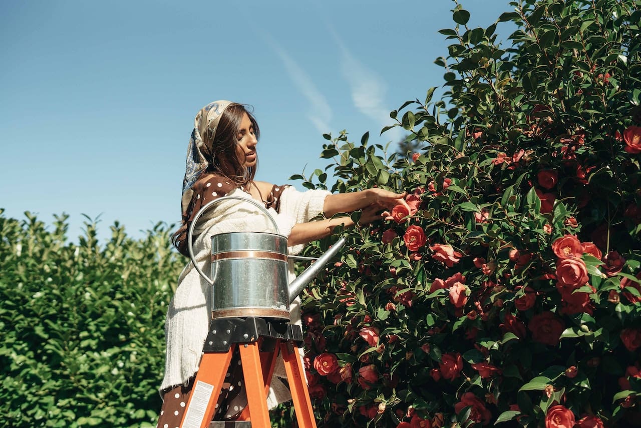 A delightful snapshot of friends tending to their backyard garden, filled with lush plants and blooming flowers, all nurtured by pure water, illustrating the city's love for gardening and sustainable living.
