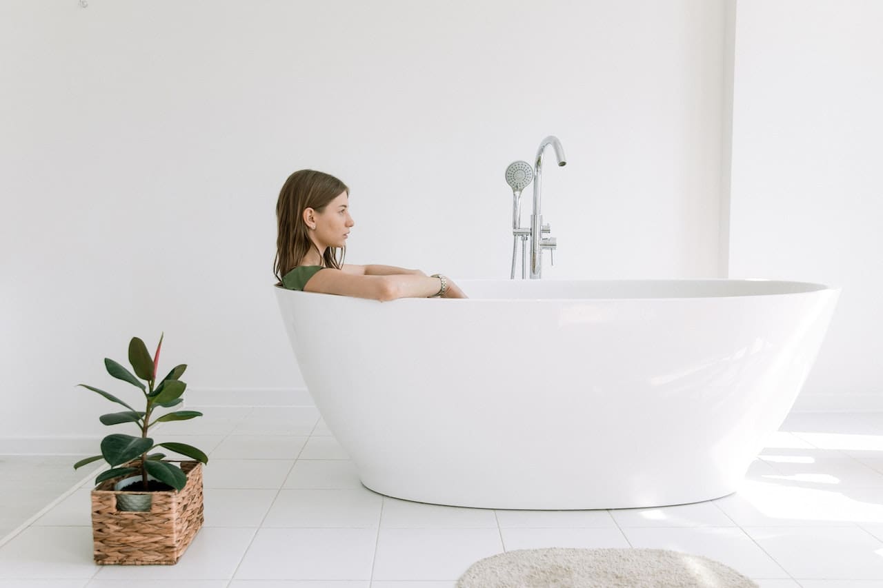 An elderly lady in Mesquite filling a bathtub with discolored water, illustrating potential issues with water quality for bathing.