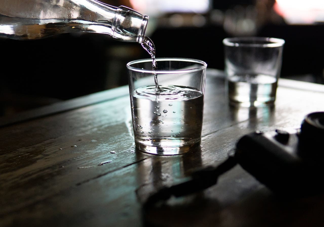 An image of a resident in McKinney pouring a glass of tap water with a noticeable odor and taste, highlighting concerns about the quality of drinking water.