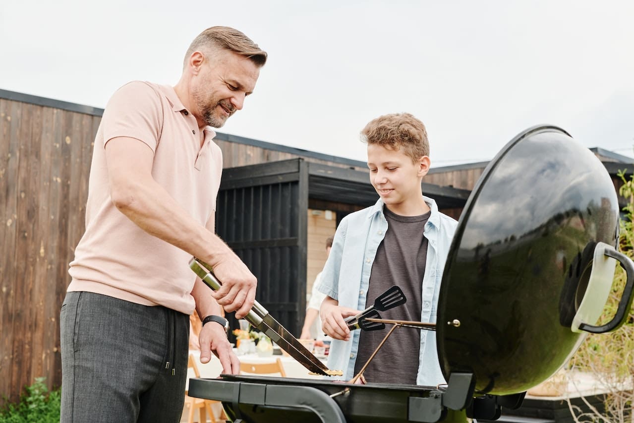 A heartwarming scene of a family enjoying a barbecue in their backyard, under the starry Texas night sky, sipping on refreshing beverages made with pure water, showcasing the warmth of home and outdoor living in New Braunfels.