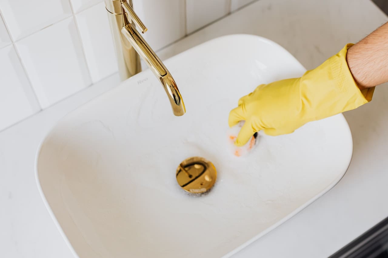 A picture of a person holding a grimy blue filter removed from a tap from a kitchen sink, emphasizing the need for filtration systems to improve water quality for everyday use in Conroe.