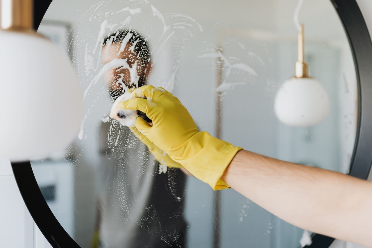 An image of a resident frustrated with soap scum and mineral buildup on bathroom tiles and fixtures, illustrating the impact of hard water and the need for filtered water in San Angelo homes.