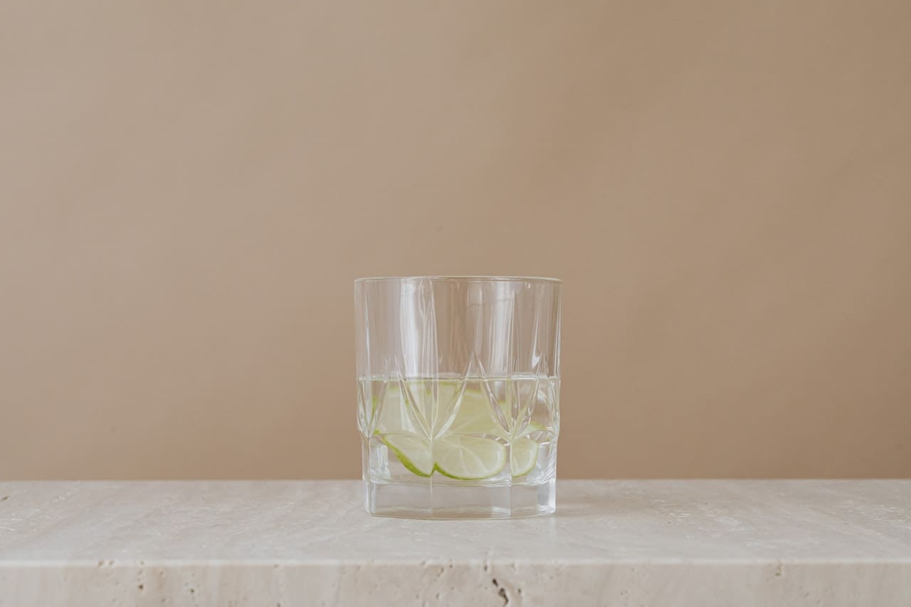 An image of a concerned homeowner inspecting a glass of tap water with visible impurities and sediment, highlighting the importance of clean, filtered water for everyday use in Bryan households.