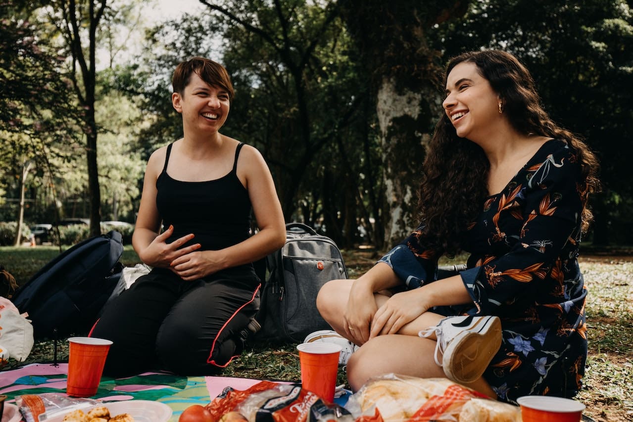 A cozy evening snapshot of friends gathered in their garden, enjoying a barbecue and outdoor games on a sunny day, with cool beverages made from pure water, illustrating the simple pleasures of outdoor living in Lewisville.