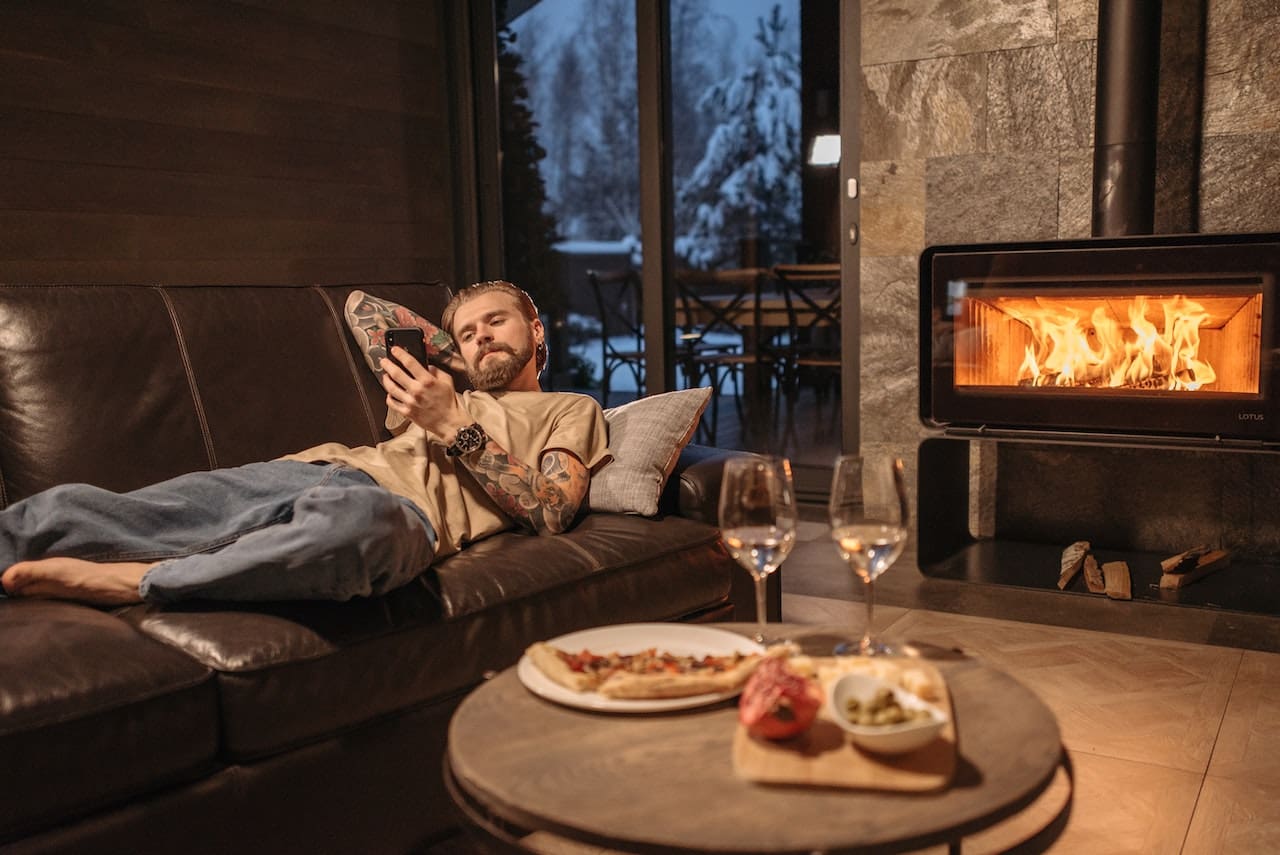 A cozy living room with a fireplace. A family gathers for storytime, with a glass bowl filled with water and floating candles as a centerpiece, creating a warm ambiance.