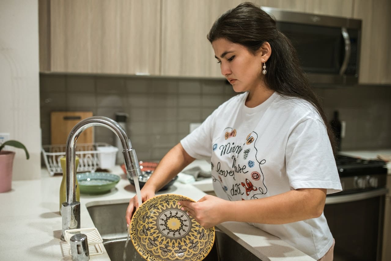 An image of a homeowner examining white spots on dishes caused by hard water stains, underlining the challenges of water quality in Wichita Falls.