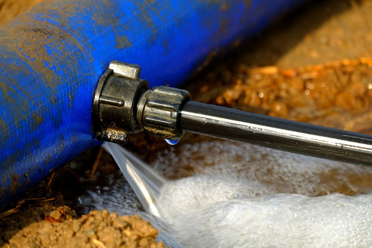 An image of a homeowner struggling with a malfunctioning sprinkler system, illustrating common water wastage issues in residential areas.